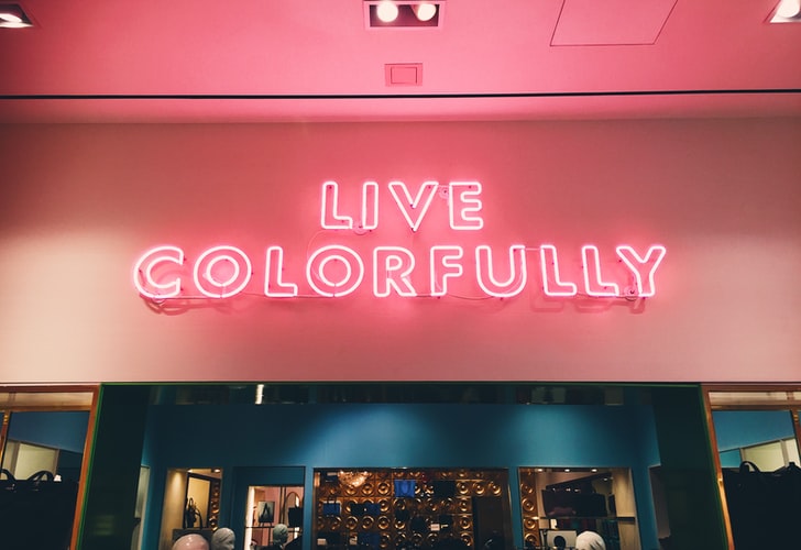 Brand Voice Artikel, Bild mit Leuchtschrift in pink/rot, die sagt "live colorfully"